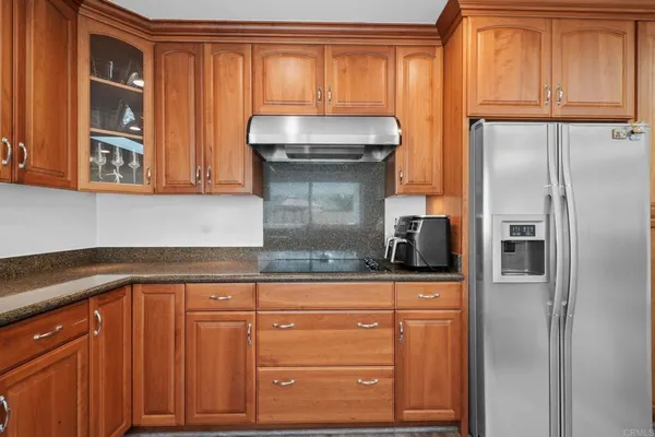 a kitchen with granite countertop white cabinets and stainless steel appliances