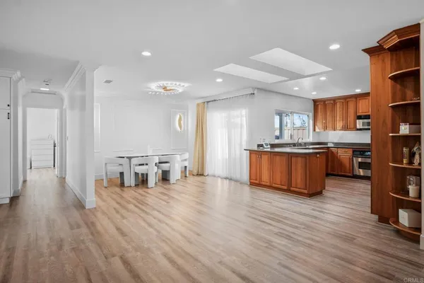 a living room with stainless steel appliances kitchen island wooden floors and kitchen view