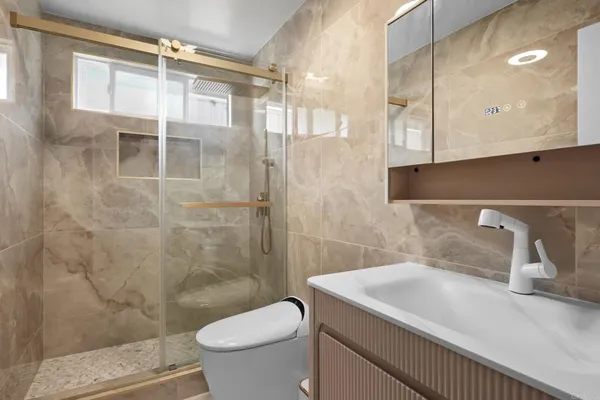 a bathroom with a sink a toilet and shower