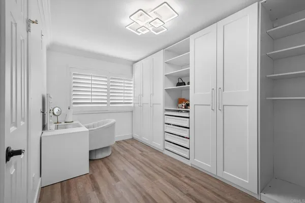 a view of walk in closet with wooden floor