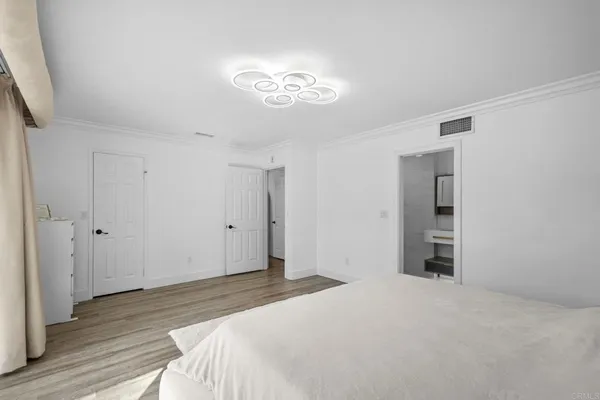 a bedroom with a bed and a chandelier