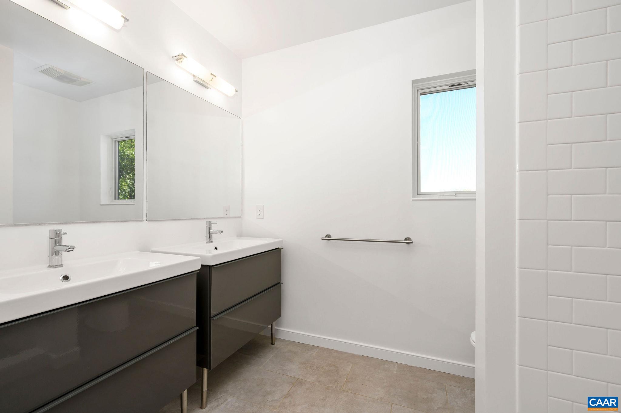 1130 East High Street, Unit J Charlottesville, VA 22902 - Photo 16 of 42 a bathroom with a double vanity sink and mirror