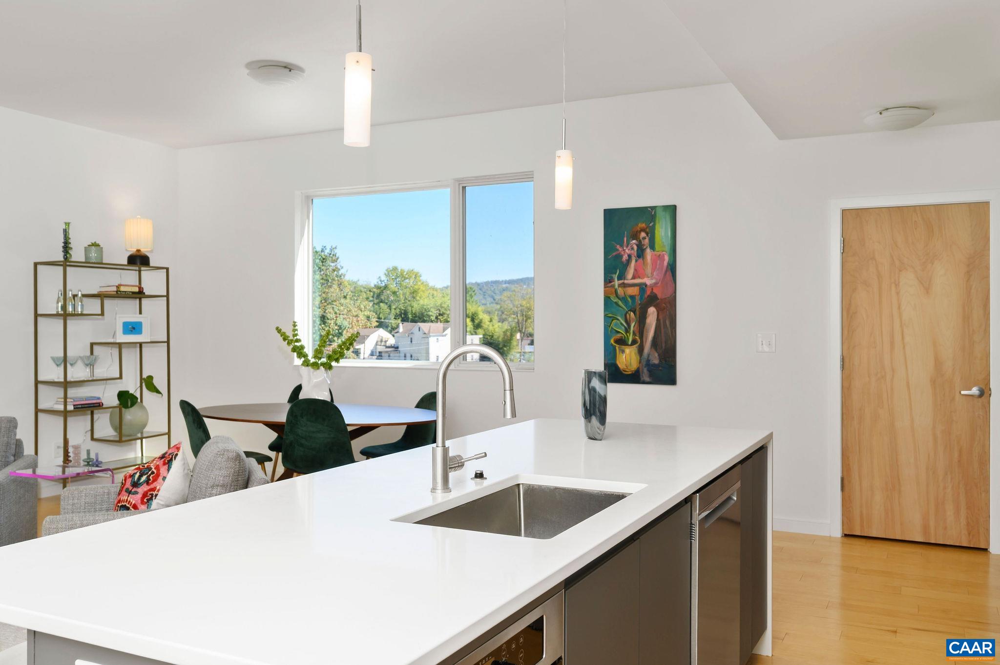 1130 East High Street, Unit J Charlottesville, VA 22902 - Photo 9 of 42 a kitchen with stainless steel appliances kitchen island granite countertop a sink and a refrigerator