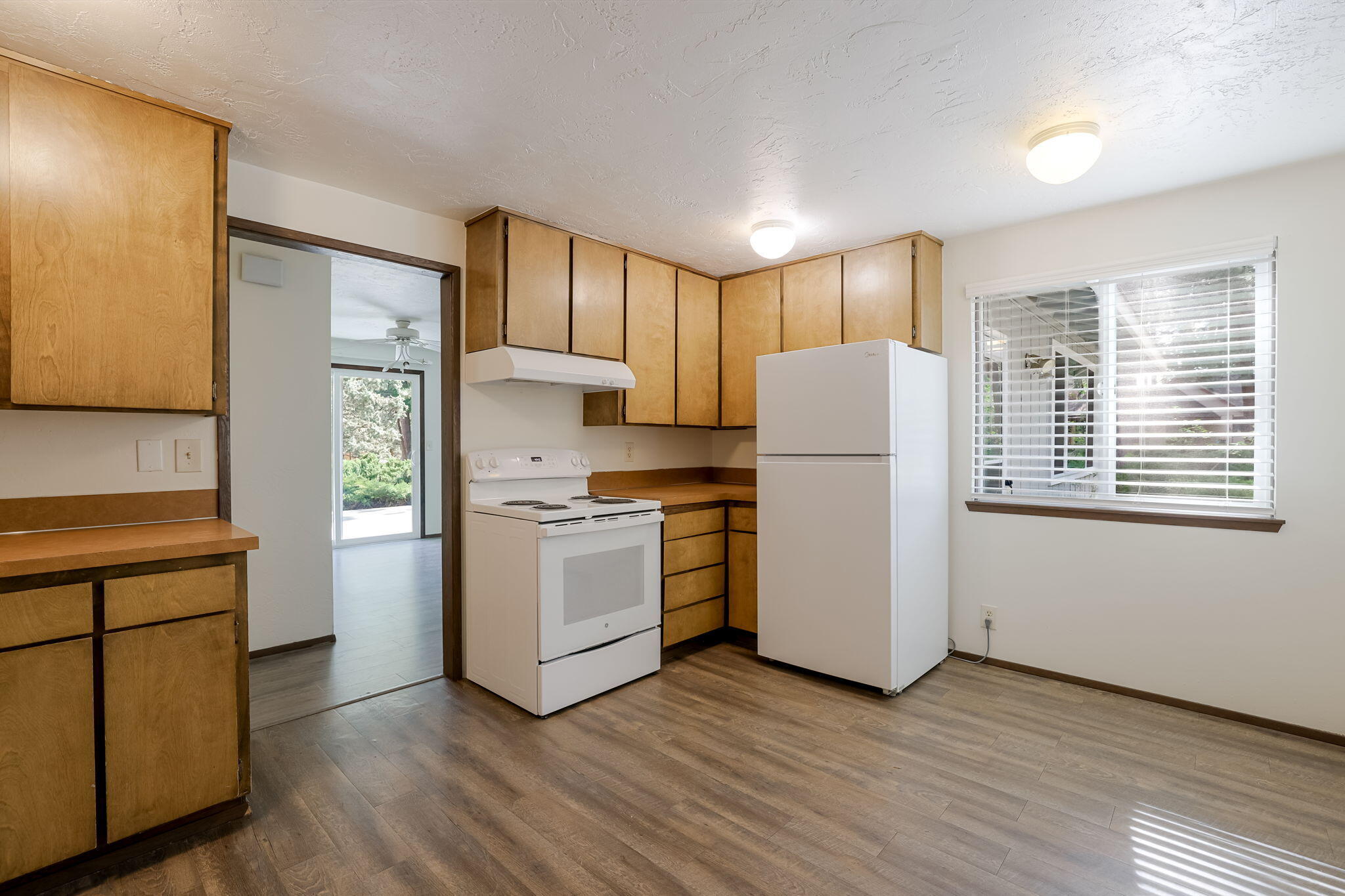 19968 Double Tree Court Bend, OR 97702 - Photo 5 of 28 a kitchen with a refrigerator stove and wooden cabinets