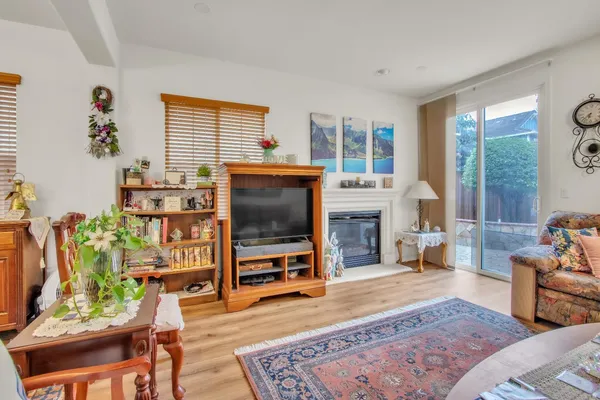 a living room with furniture a flat screen tv and a floor to ceiling window