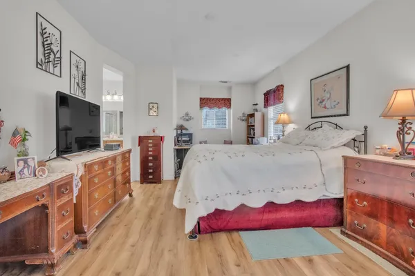 a large bedroom with a bed and a flat screen tv