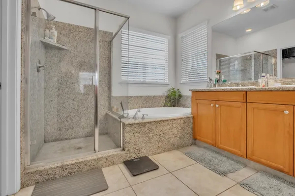 a bathroom with a granite countertop bathtub shower sink and mirror