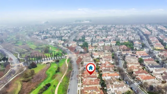 an aerial view of residential houses with outdoor space and trees