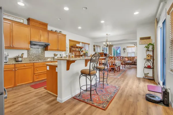 a kitchen with stainless steel appliances wooden floor dining table and chairs