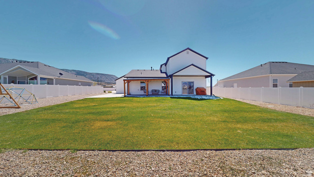 1127 4240 North Enoch, UT 84721 - Photo 52 of 56 Back of house with a mountain view, a patio area, and a fenced backyard