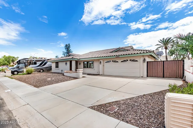 a front view of a house with a yard and car parked