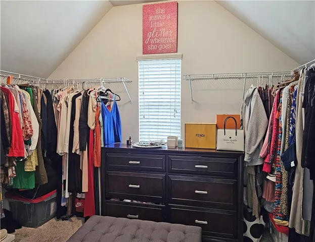 a view of walk in closet with clothes