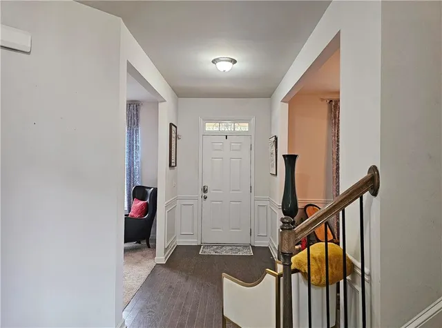 a view of a hallway with wooden floor and stairs