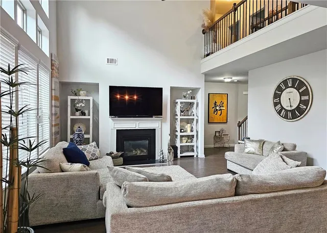 a living room with furniture a large window and a fireplace