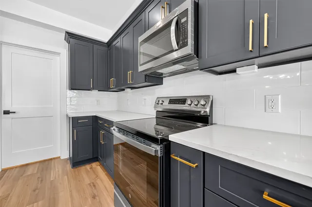 a kitchen with stainless steel appliances a sink stove and cabinets