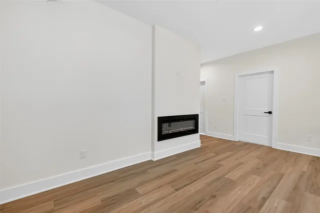 a view of a hallway with wooden floor and a chandelier