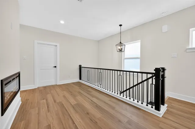 a view of a livingroom with wooden floor and staircase