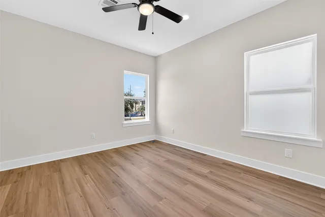 a view of empty room with wooden floor