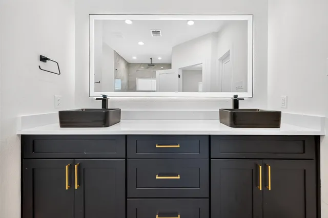 a spacious bathroom with a double vanity sink a mirror and a bathtub