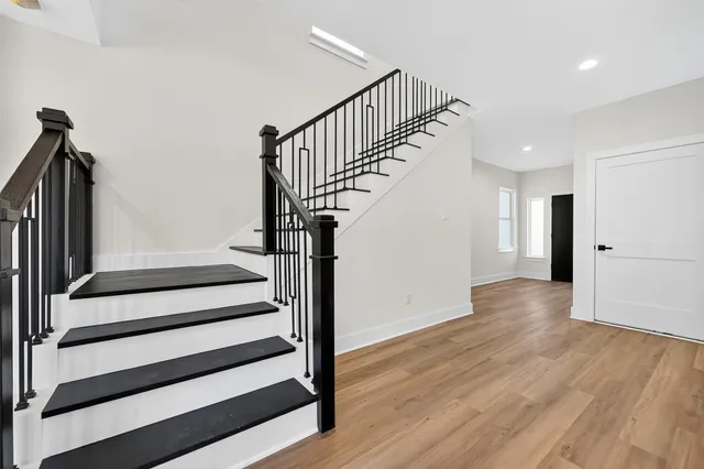 a view of a hallway with wooden floor and staircase