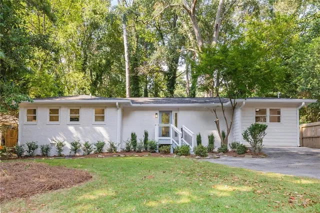 front view of house with a yard and potted plants