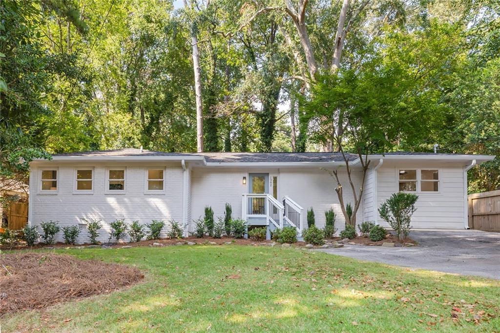 front view of house with a yard and potted plants