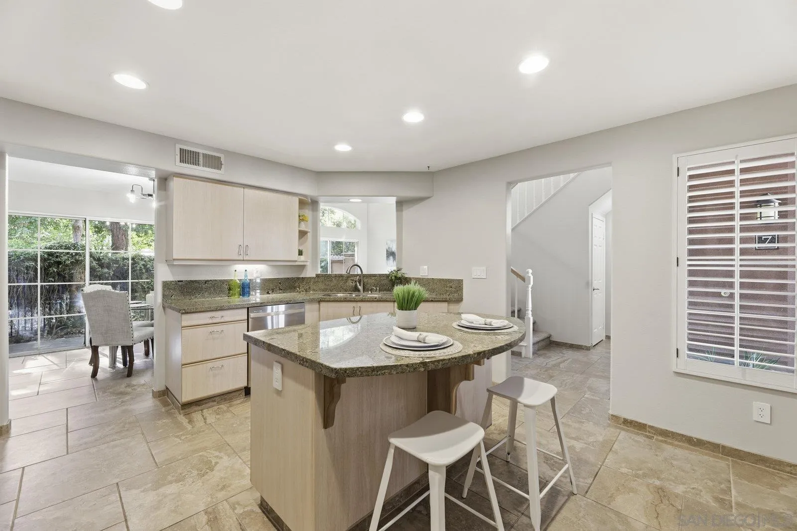 11908 Tivoli Park Row, Unit 7 San Diego, CA 92128 - Photo 11 of 34 a kitchen with a dining table chairs and stove