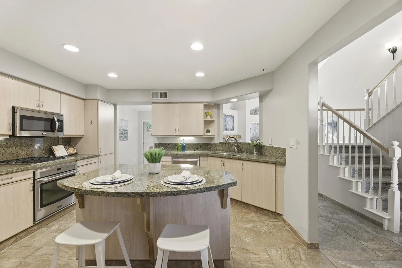 11908 Tivoli Park Row, Unit 7 San Diego, CA 92128 - Photo 12 of 34 a kitchen with a dining table chairs stainless steel appliances and cabinets