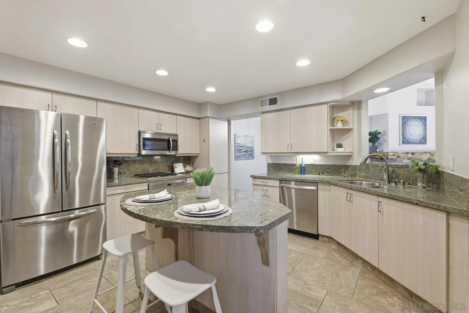 11908 Tivoli Park Row, Unit 7 San Diego, CA 92128 - Photo 13 of 34 a kitchen with stainless steel appliances granite countertop a sink a stove a refrigerator and white cabinets with wooden floor