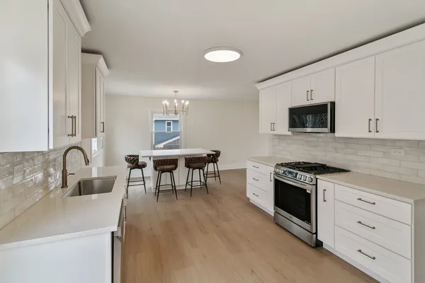 a kitchen with white cabinets and appliances