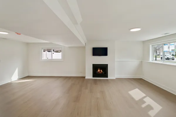 a view of an empty room with a fireplace and a window
