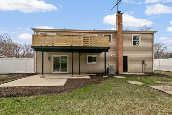 a view of a house with yard and wooden fence