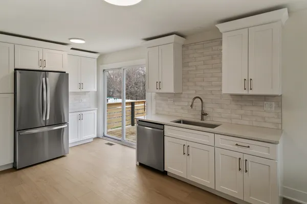 a kitchen with stainless steel appliances granite countertop a refrigerator sink and cabinets