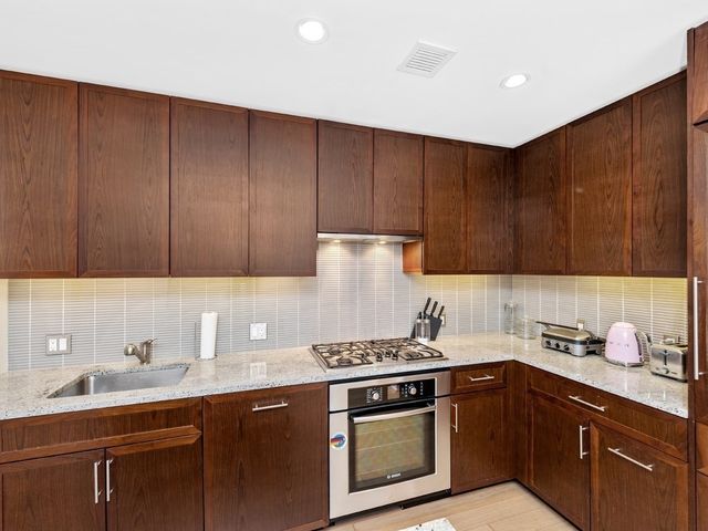 a kitchen with sink cabinets and stainless steel appliances
