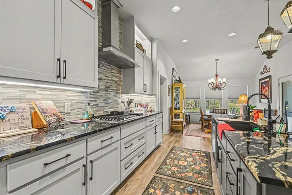 a kitchen with granite countertop lots of clutter and stainless steel appliances