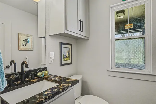 a bathroom with a granite countertop sink and a mirror