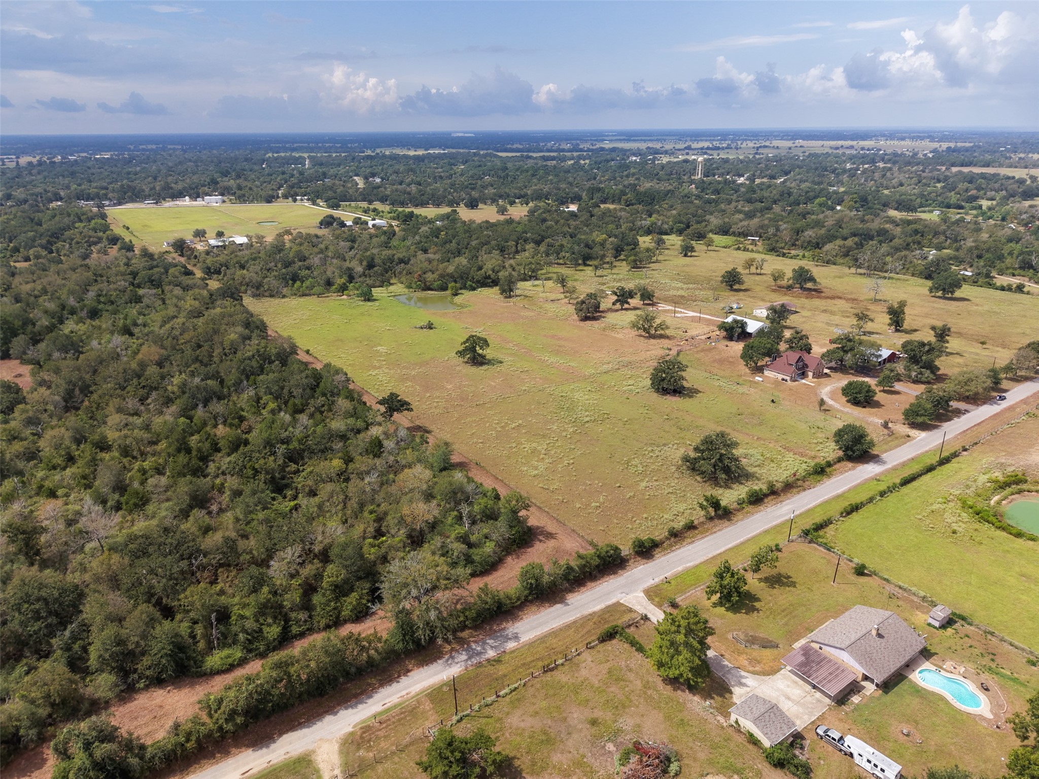 38021 Wiggins Road Hempstead, TX 77445 - Photo 5 of 19 Elevated aerial view highlighting the property’s convenient road access and combination of open and wooded acreage.