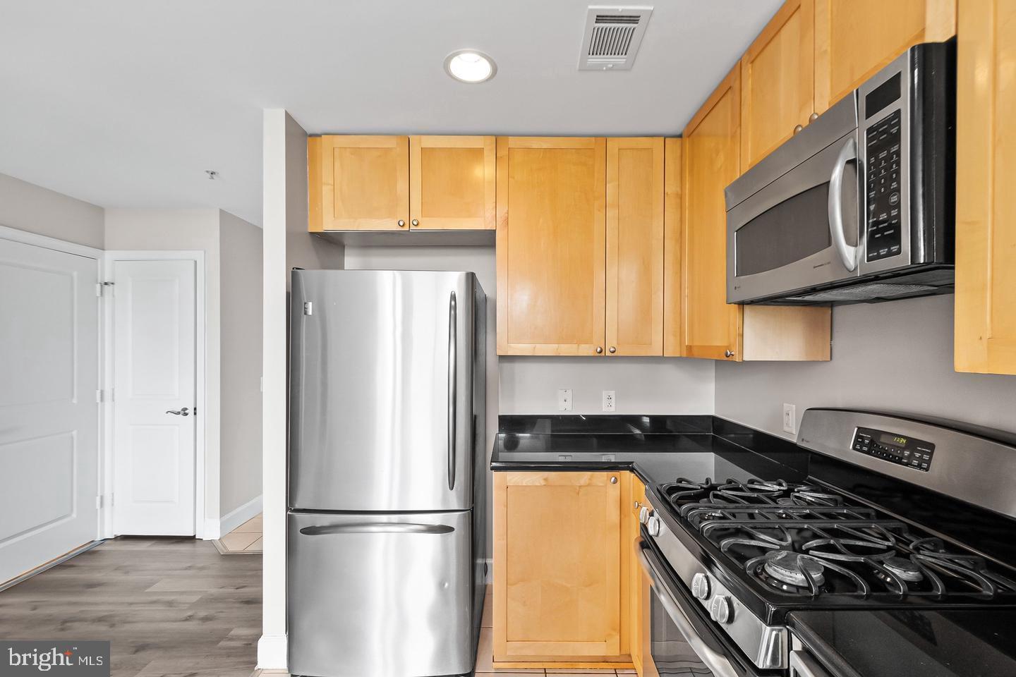 3600 South Glebe Road, Unit 330W Arlington, VA 22202 - Photo 12 of 35 a kitchen with stainless steel appliances granite countertop a stove a refrigerator and a microwave