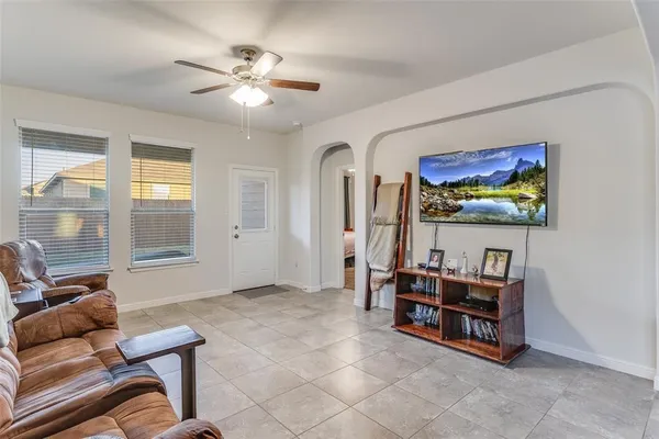 a living room with furniture and a ceiling fan