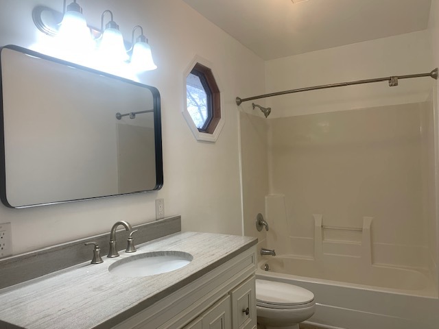 1818 Carr Street Streator, IL 61364 - Photo 24 of 45 a bathroom with a granite countertop sink toilet a mirror a vanity and shower