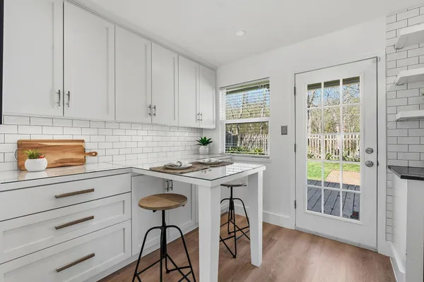 a kitchen with a stove a refrigerator and a stove with wooden floors