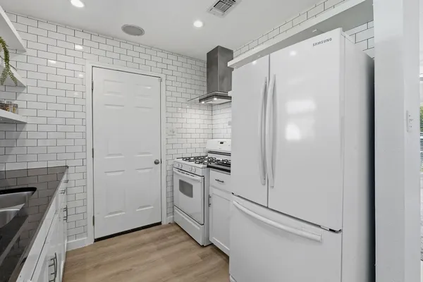 a kitchen with a refrigerator stove and cabinets