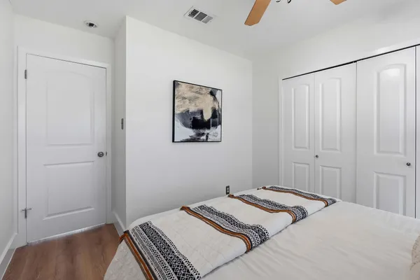 a bedroom with a bed and a painting on the wall