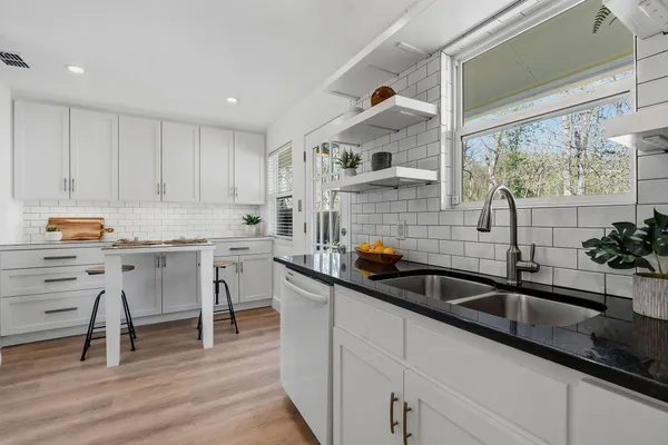 a kitchen with stainless steel appliances a sink a stove and wooden floor
