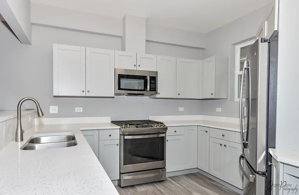 a kitchen with white cabinets and white appliances