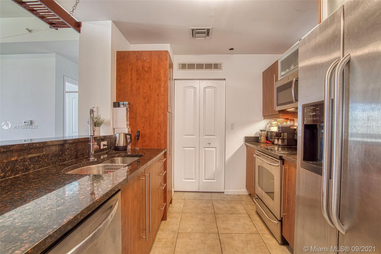7355 Southwest 89th Street, Unit 425N Miami, FL 33156 - Photo 12 of 22 a kitchen with granite countertop a refrigerator and a sink