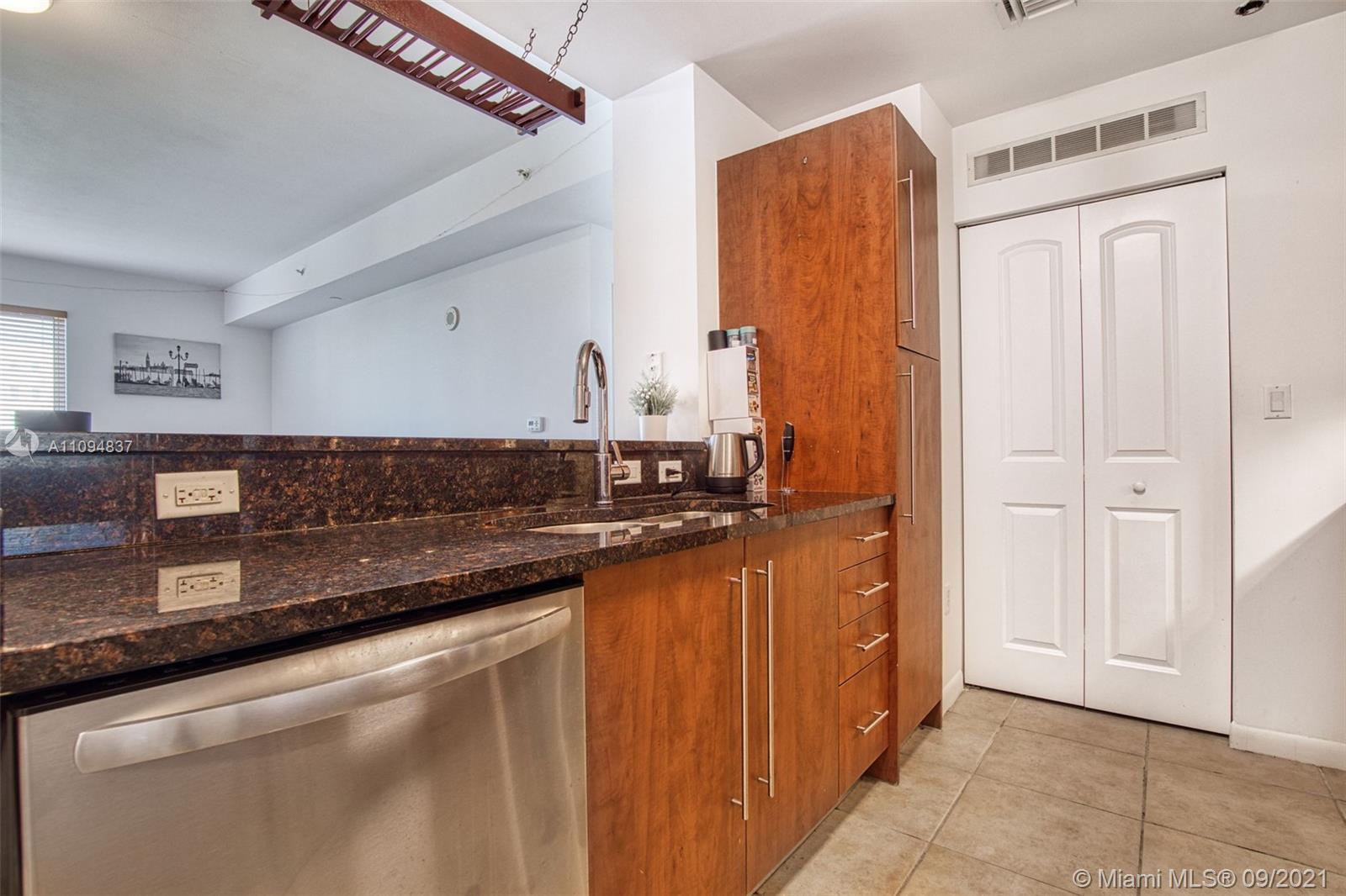 7355 Southwest 89th Street, Unit 425N Miami, FL 33156 - Photo 13 of 22 a kitchen with stainless steel appliances granite countertop a sink and a refrigerator