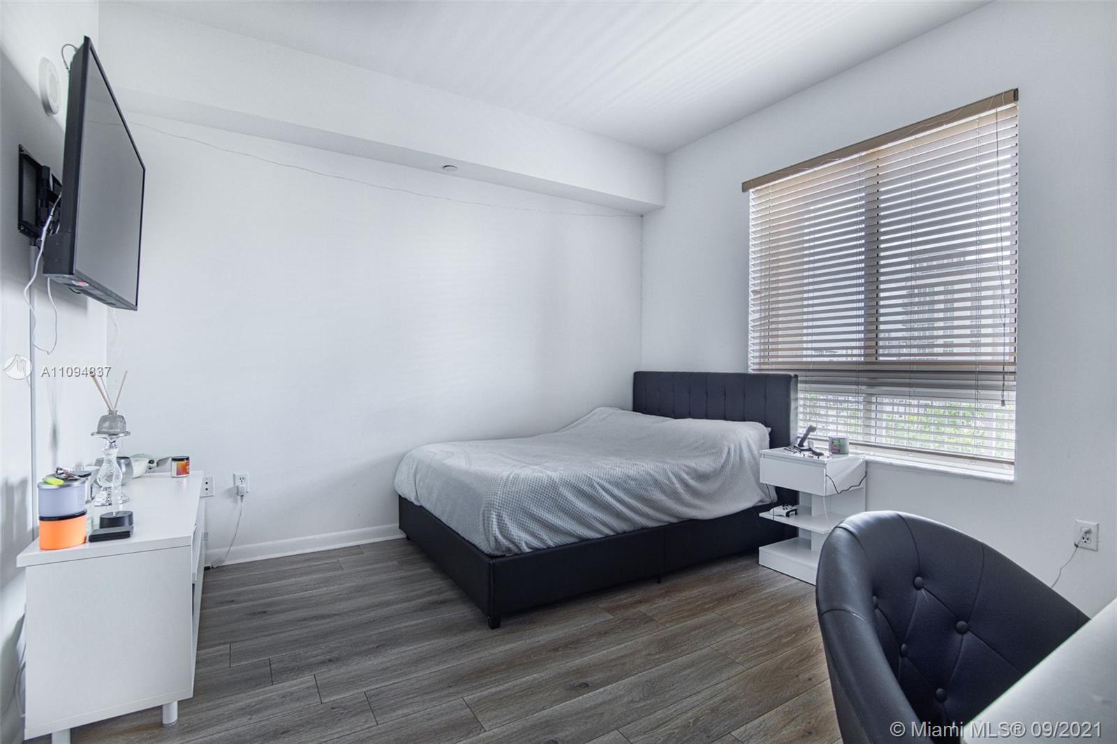 7355 Southwest 89th Street, Unit 425N Miami, FL 33156 - Photo 15 of 22 a bedroom with a bed wooden floor and flat screen tv