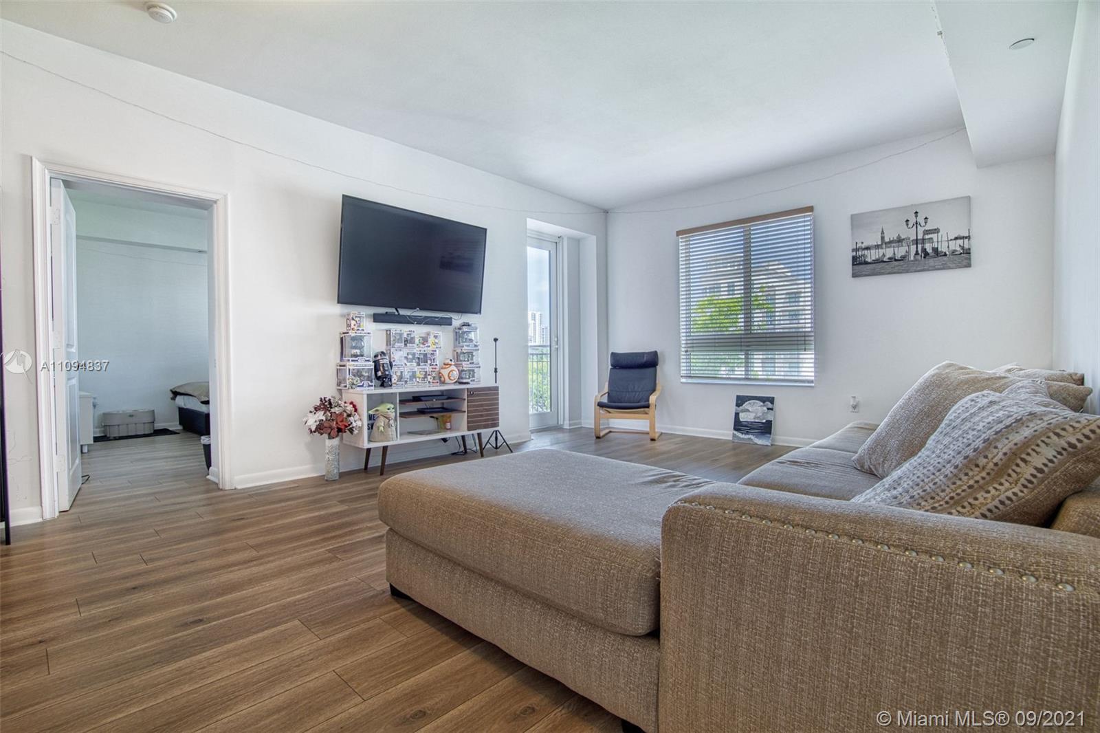 7355 Southwest 89th Street, Unit 425N Miami, FL 33156 - Photo 6 of 22 a living room with furniture and a flat screen tv