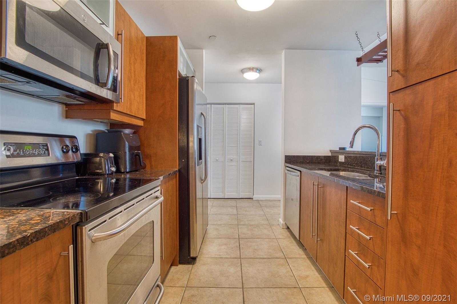 7355 Southwest 89th Street, Unit 425N Miami, FL 33156 - Photo 10 of 22 a kitchen with stainless steel appliances granite countertop a refrigerator and a stove